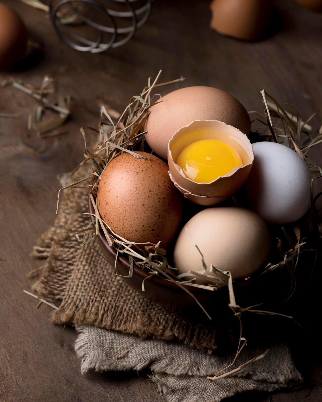 Pregnant woman holding a bowl with organic eggs in UAE kitchen